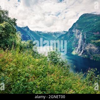 Amazing summer scene of Sunnylvsfjorden fjord, Geiranger village location, western Norway. Majestic view of famous Seven Sisters waterfalls. Beauty of Stock Photo