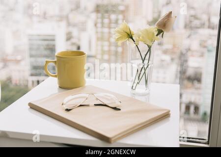 glasses book near flowers mug table. High quality and resolution beautiful photo concept