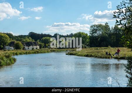 Chilbolton Cow Common SSSI with a family having a picnic by the river test, Hampshire, UK, during September Stock Photo