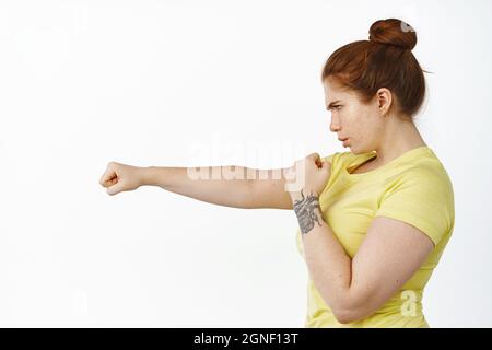 Woman doing boxing workout holding hand weights. Female doing shadow boxing  exercise against a wall. stock photo