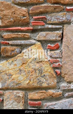 Traditional stone wall, with yellow, orange and blue stones. Ideal for background Stock Photo