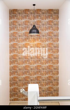room with a modern pendant lamp turned on, decorating a room with a colordian wallpaper and abstract in the background, decoration and backgrounds Stock Photo