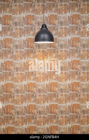 a modern pendant lamp is on, decorating a room with a colordian wallpaper and abstract in the background, decoration and backgrounds Stock Photo