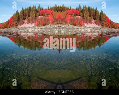 moss on rocks under water in a autumn landscape with trees,  rocks in red tones a mirrored photo Stock Photo