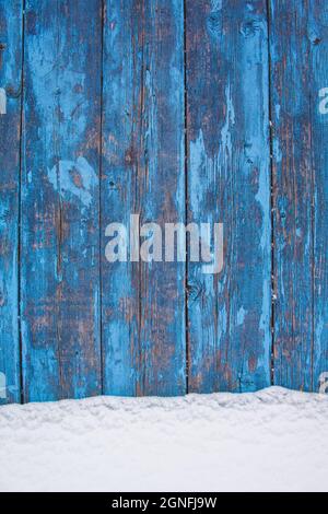 blue wood texture background with untouched snow, peeling paint on wood in winter Stock Photo