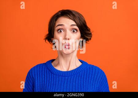 Photo of impressed brunette short hairdo lady wear blue sweater isolated on orange color background Stock Photo
