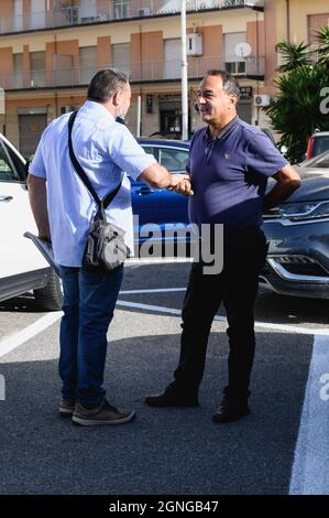 Locri, Italy. 25th Sep, 2021. Domenico Lucano (R) seen talking to his supporter before the trial, The pro-migrant former Mayor of Riace, Domenico “Mimmo” Lucano, arrived at Locri's courthouse for the defensive conclusive statements of the trial for illegal immigration charges. The final session of the trial has been scheduled for September 27, 2021. Lucano is also running for upcoming regional elections with the list “Un'altra Calabria è possibile”. Credit: SOPA Images Limited/Alamy Live News Stock Photo