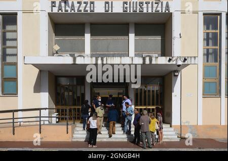 Locri, Italy. 25th Sep, 2021. People are seen waiting outside Locri's courthouse.The pro-migrant former Mayor of Riace, Domenico “Mimmo” Lucano, arrived at Locri's courthouse for the defensive conclusive statements of the trial for illegal immigration charges. The final session of the trial has been scheduled for September 27, 2021. Lucano is also running for upcoming regional elections with the list “Un'altra Calabria è possibile”. Credit: SOPA Images Limited/Alamy Live News Stock Photo