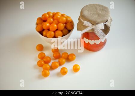 cherry plums yellow Jam, fresh fruits homemade marmalade glass jar on white background Stock Photo