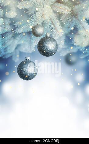 Christmas balls on a blue Christmas tree branch over blurred shiny background. Space for text. Stock Photo