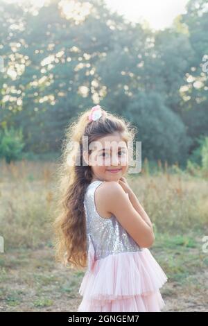 Child playing on outdoor playground. Healthy summer activity for children in sunny weather. Cute girl smiling Stock Photo