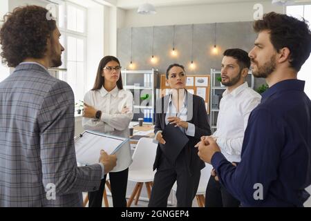 Serious people colleagues in the office discuss and plan a business plan for a new future project. Stock Photo