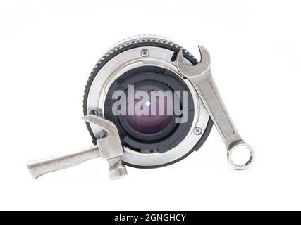 Close-up of a camera lens with a hand tools kit isolated on white. Repair and service concept. Stock Photo