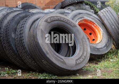 Stack of old used tires of different sizes and types in abandoned scrap yard. Issue of recycling, pollution and ecology in the light of global warming Stock Photo