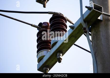 Ceramic insulators on low voltage pylons. Photo taken in good lighting conditions on a sunny day. Stock Photo