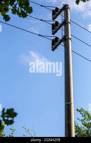 Ceramic insulators on low voltage pylons. Photo taken in good lighting conditions on a sunny day. Stock Photo