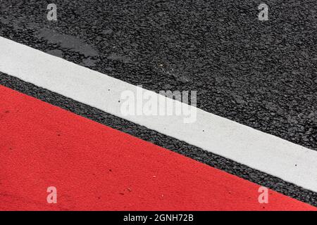 Asphalt decorated with a white line and a red field Stock Photo