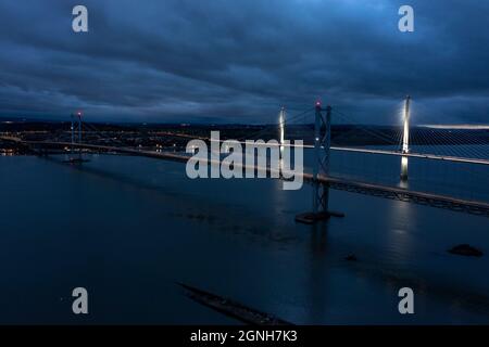 South Queensferry, Eaglesham, Scotland, UK. 25th Sep, 2021. PICTURED: Night aerial drone view of Forth bridges. Forth Road Bridge seen with no traffic on it. Since a crack was discovered in part of the bridges structure and subsequently repaired, the bridge had seen light traffic, with the new Queensferry Crossing being built, which now takes the majority of vehicles, the Forth Road Bridge still takes busses and taxis. Credit: Colin Fisher/Alamy Live News Stock Photo