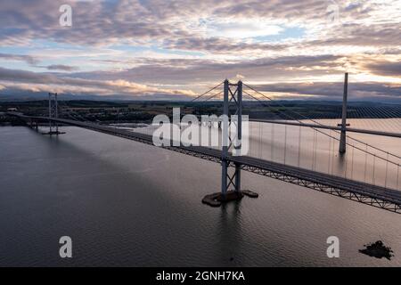 South Queensferry, Eaglesham, Scotland, UK. 25th Sep, 2021. PICTURED: Aerial drone view of Forth bridges. Forth Road Bridge seen with no traffic on it. Since a crack was discovered in part of the bridges structure and subsequently repaired, the bridge had seen light traffic, with the new Queensferry Crossing being built, which now takes the majority of vehicles, the Forth Road Bridge still takes busses and taxis. Credit: Colin Fisher/Alamy Live News Stock Photo