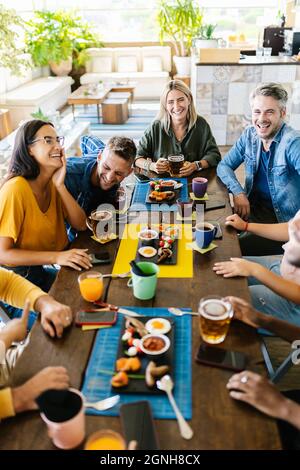 Group of young people having fun drinking on a rooftop terrace of a restaurant Stock Photo