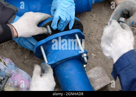 Workers installing water supply pipeline system, close up. Stock Photo