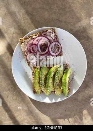 Top view delicious sliced avocados and red onion cracker bread Stock Photo