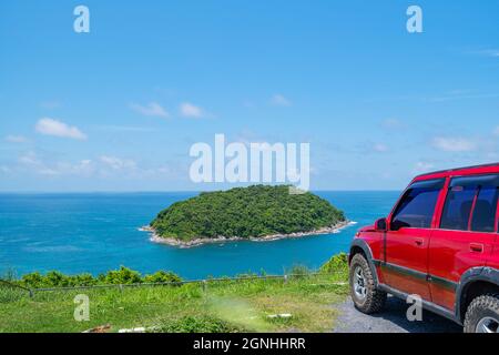 Red SUV 4x4 car on the mountain with Summer sea and small island background of free space for summer text and travel transportation background. Stock Photo
