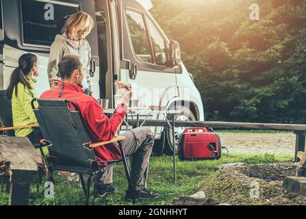 Three Caucasian Friends in Their 40s on RV Road Trip. Overnight Dry Camping Stay  in a Wilderness. Recreational Vehicle Theme. Stock Photo