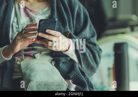 Caucasian Woman in Her 40s with Smartphone in an Airport Waiting Room. Browsing Internet Using Free WiFi Network. Stock Photo