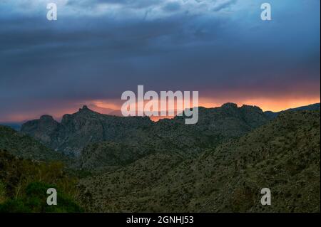 Dramatic sunset sky with monsoon rain over Thimble Peak in Tucson Stock Photo