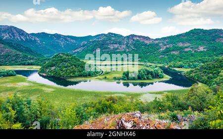 Tranquil waters of the Crnojevica river with strange sleeves stretched out among the mountain hills. Aerial view of meandering canyon near Skadar lake Stock Photo
