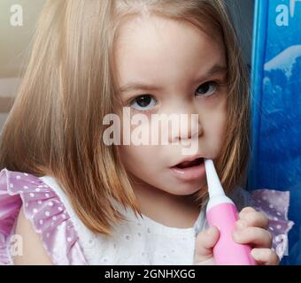 Little baby girl brushing teeth portrait close up view Stock Photo