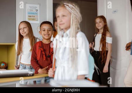 Smiling kids standing in class at school Stock Photo