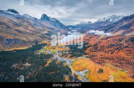 View from flying drone. Gloomy autumn view of Sils lake. Dramatic morning scene of Swiss Alps. Aerial outdoor scene of Maloya village, Switzerland, Eu Stock Photo