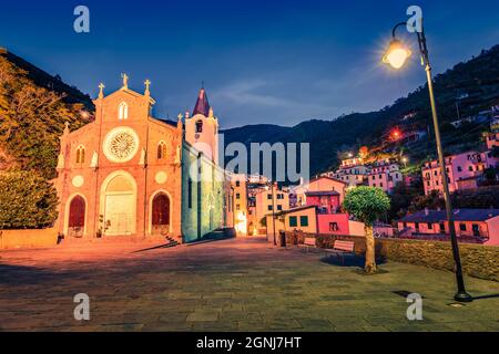 Colorful evening view of cityscape of Church of San Giovanni Battista of Riomaggiore. Night cityscape of Riomaggiore, first city of Cique Terre sequen Stock Photo
