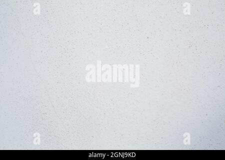 White wall plaster with grey dots. Background picture. Concrete surface panted in light color. Wallpaper textured picture. top view Stock Photo
