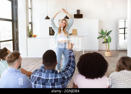 Group of millennial diverse friends playing charades at home Stock Photo