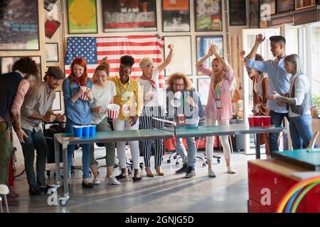 people at work playing beer pong, having a great time. team building concept Stock Photo