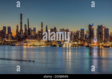 The Manhattan skyline in New York City during morning twilight as viewed over the Hudson River from New Jersey. Stock Photo