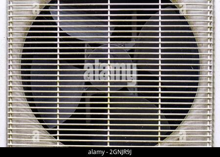 Close Up Of A Domestic Air Conditioning Unit And Fan With A Safety Grill In Place And no People Stock Photo