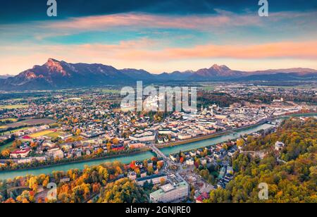 Aerial view from flying drone of Salzburg town. Amazing autumn sunrise on Eastern Alps. Splendid landscape with Salzach river. Traveling concept backg Stock Photo