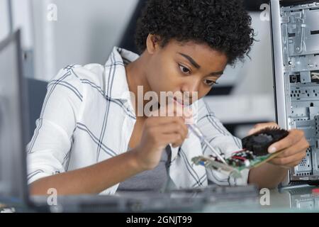 young female computer repairer using screwdriver Stock Photo