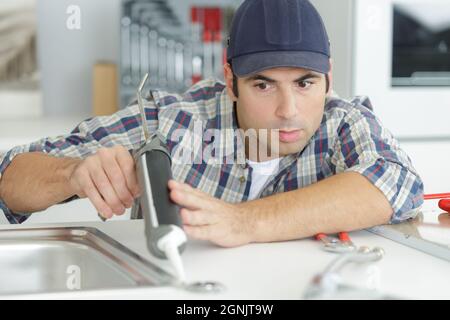 plumber using a silicone tube on a sink Stock Photo