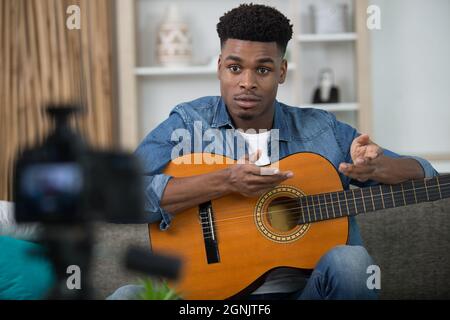 man with guitar filming tutorial for a blog Stock Photo
