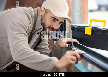 male worker installing sill on external pvc window frame Stock Photo