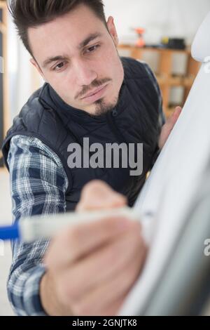 man writes on a white board Stock Photo