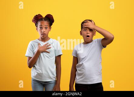 Shocked african american brother and sister on yellow Stock Photo