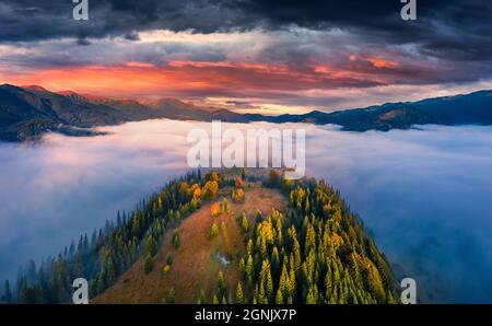 Aerial landscape photography. Sea of fog covered mountain valleys and hills. Dramatic summer view from flying drone of Carpathian mountains, Ukraine, Stock Photo