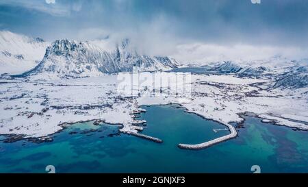 Aerial landscape photography. Misty morning view from flying drone of Vestersand port. Breathtaking winter seascape of Norwegian sea. Panoramic view o Stock Photo