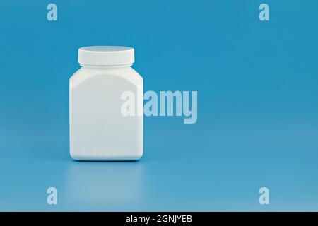 medical jar template for branding, text and design. white unbranded jar on blue background. medical bottle mockup with copy space Stock Photo